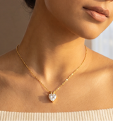 Woman wearing a necklace with a heart pendant in a bright room