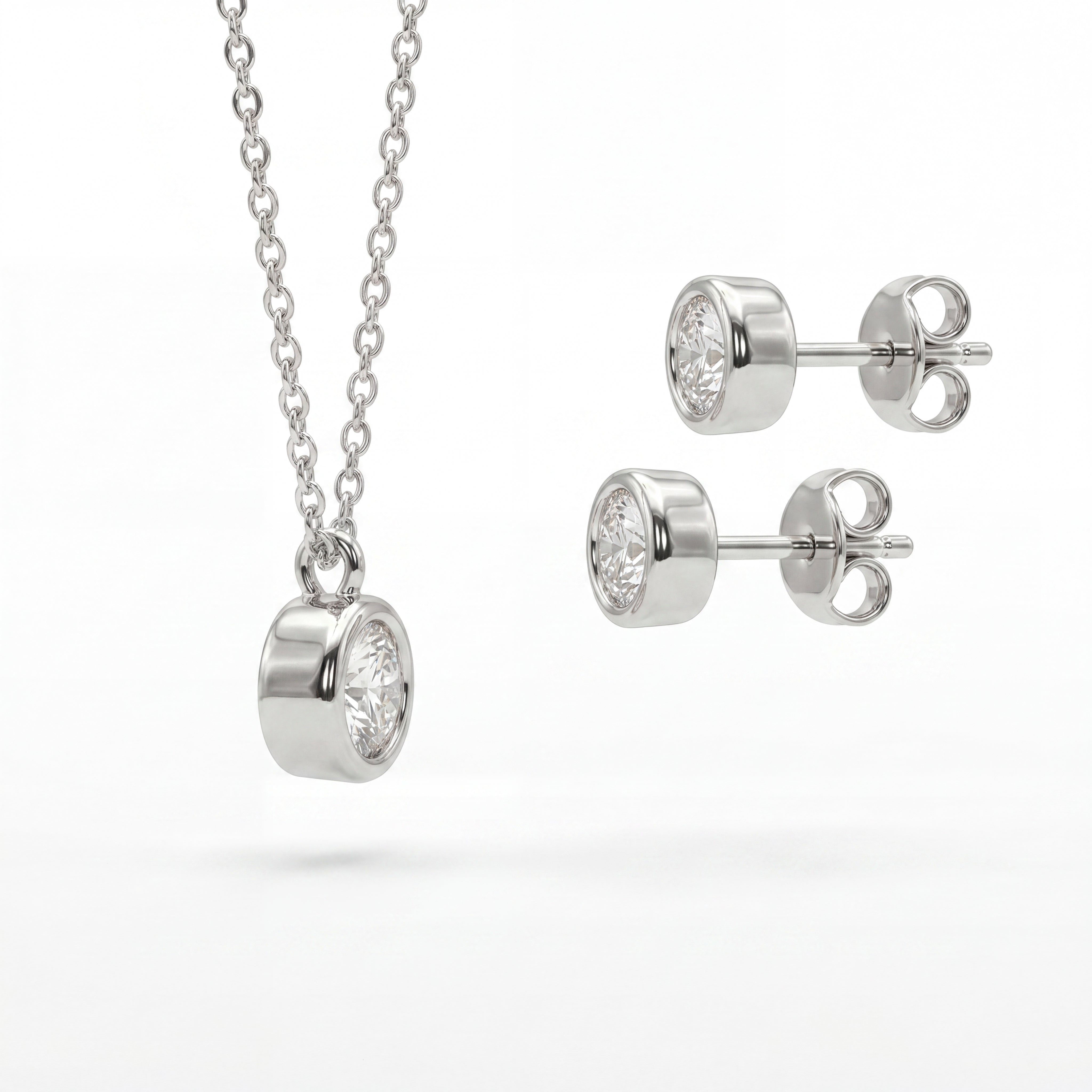 Silver necklace and earrings set on a white background