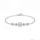 Silver bracelet with heart and square diamond charms on a white background
