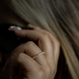Close-up of a hand wearing a diamond ring with blurred background