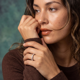 Woman wearing a brown sweater with a blurred background