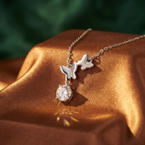 Silver butterfly necklace with a diamond pendant on a brown fabric background