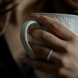 Hand holding a white mug with a blurred background