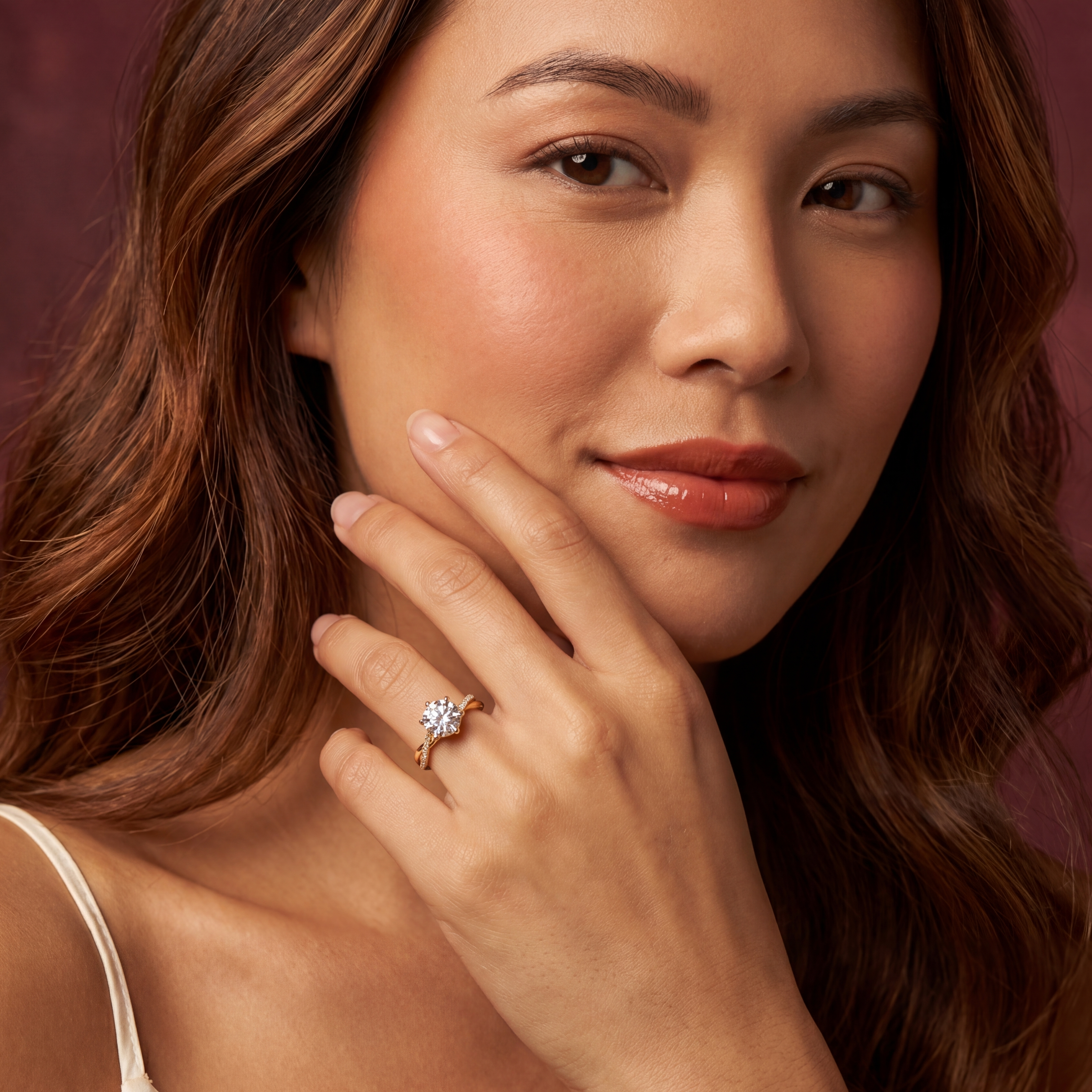 Woman wearing a ring with a blue gemstone against a warm-toned background