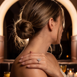 Woman in a restaurant setting with a ring on her finger, back to the camera