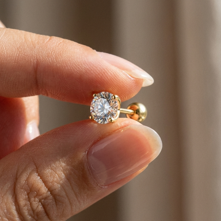 The MOHRA 1ct gold moissanite solitaire studs held in hand, showing true size