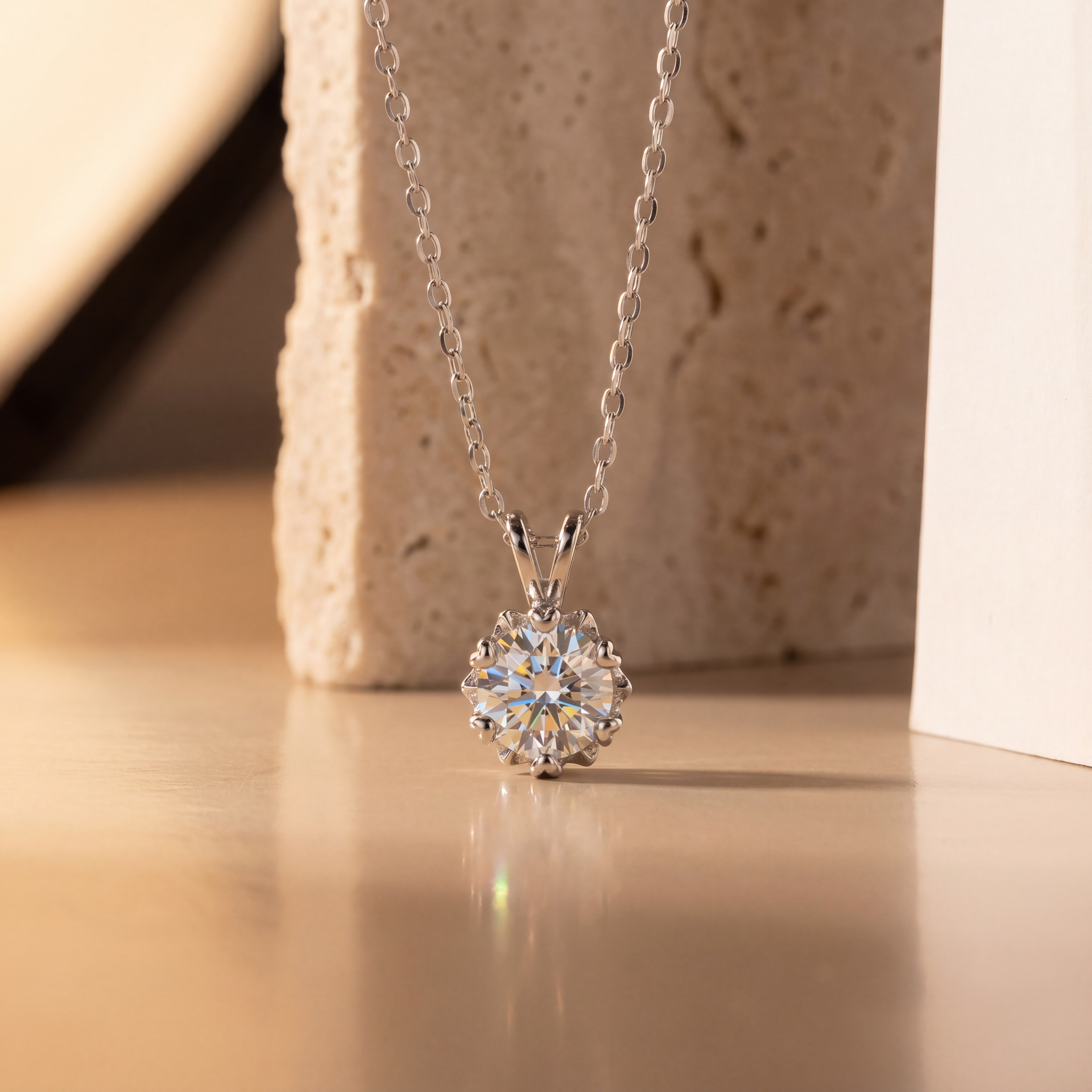 Silver necklace with a round diamond pendant on a beige surface